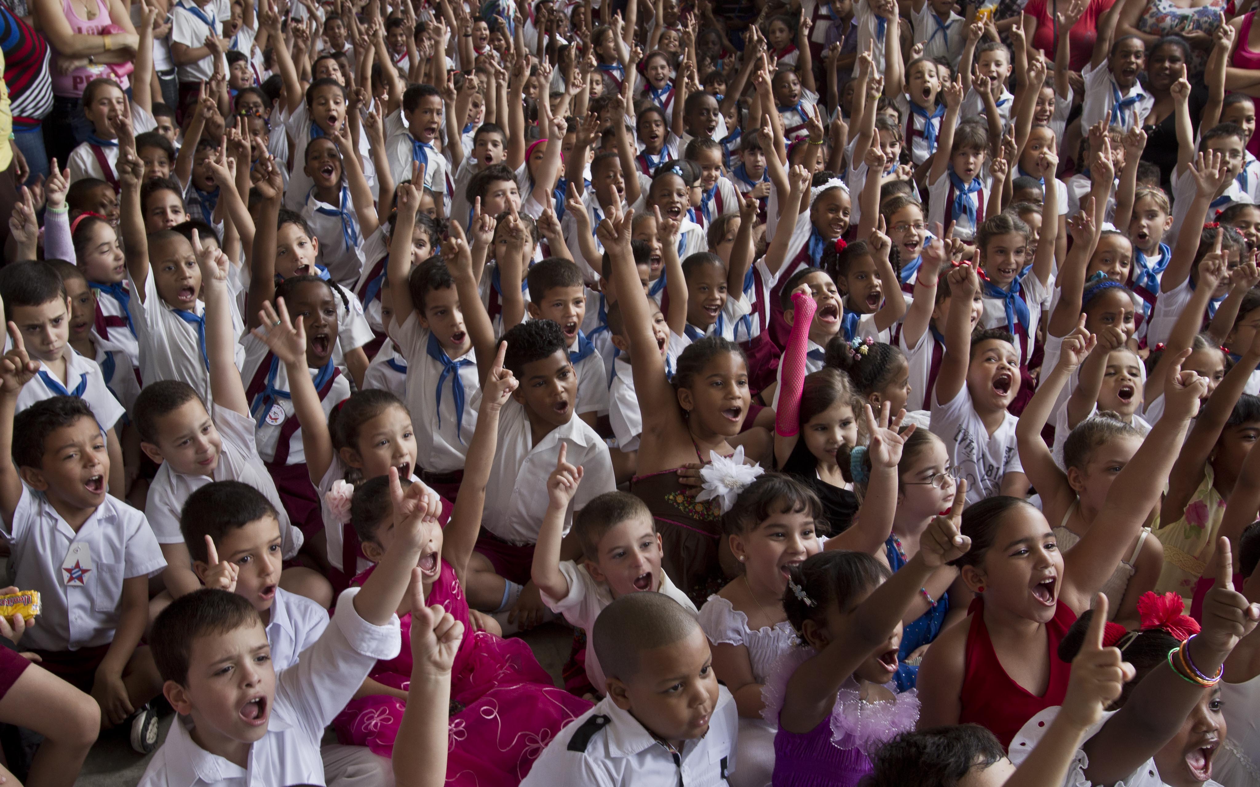 Young students cheer during a celebration to mark the anniversaries of the Organization of Cuban Pioneers and of the Union of Communist Youth at the Angela Landa elementary school in Old Havana, Cuba, Friday, April 4, 2014. Cuban schoolchildren are referred to as "pioneers," and the organization was founded in 1961 to encourage the values of education and social responsibility among children and adolescents. (AP Photo/Franklin Reyes) ORG XMIT: XFR105
